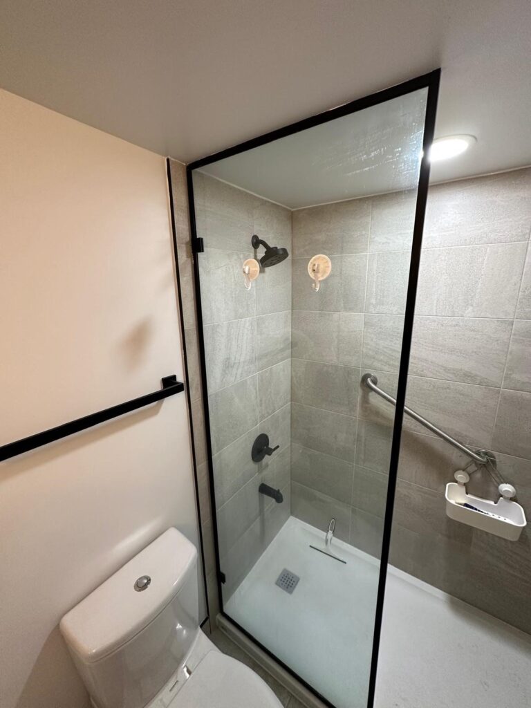 A fresh take on a stand-up shower design featuring glass doors, large tiles, and minimalist fixtures. Built for a clean, open look that makes the space feel larger and brighter.