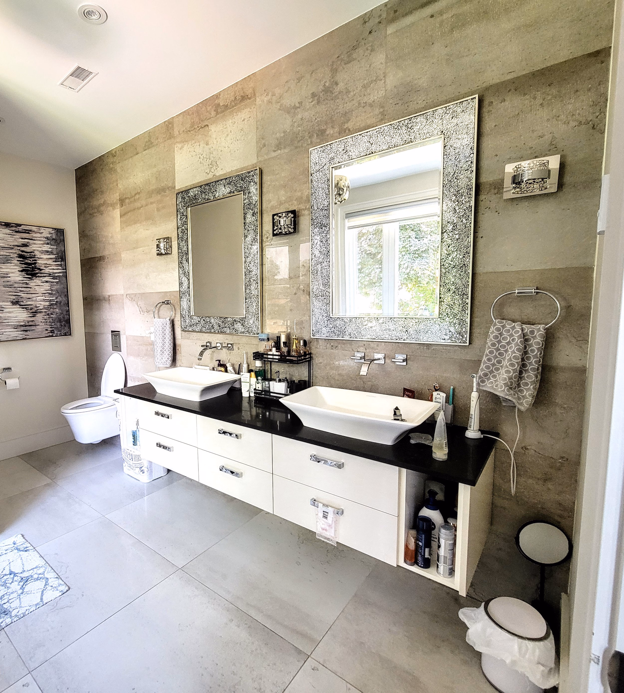 This renovation highlights bold, floor-to-ceiling tiling paired with sleek black fixtures. A refined modern look that blends texture and contrast seamlessly.