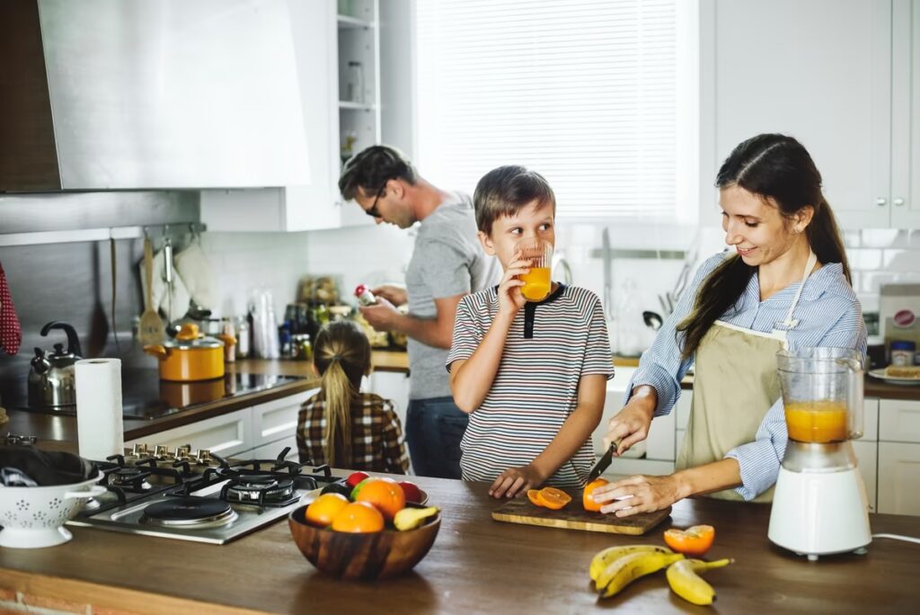 Family spending a morning together in the kitchen, preparing breakfast and fresh juice.