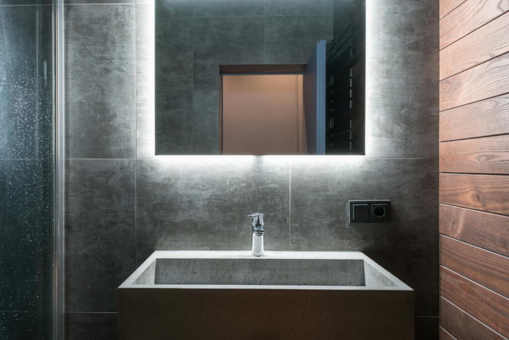 Modern bathroom in Toronto featuring a stylish mirror above the sink, sleek fixtures, and clean contemporary design highlighting expert renovation craftsmanship.